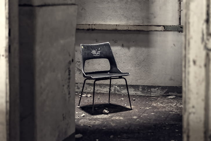 gray metal chair inside concrete room