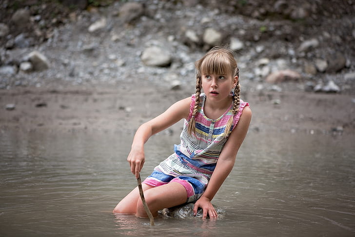 girl sitting on rock in water