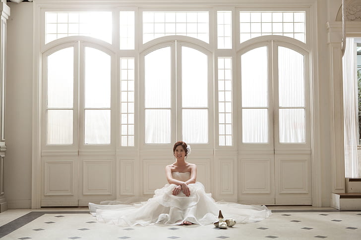woman wearing white floral wedding dress near window