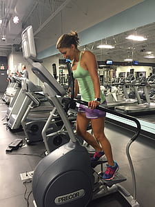 woman in green tank top using Precor exercise equipment