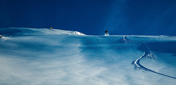 man on top of snowy hill during daytime