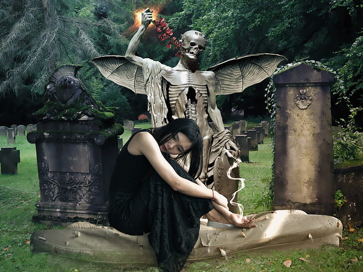 photo of woman sitting beside winged skeleton tomb