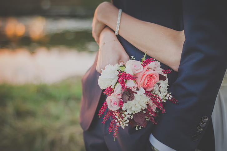 woman hugging a man while holding flower bouquet