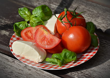 sliced tomatoes, basil, and parmesan cheese served on plate