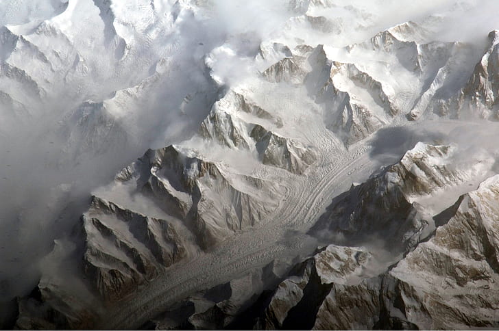 aerial photography of road in between snow capped mountains