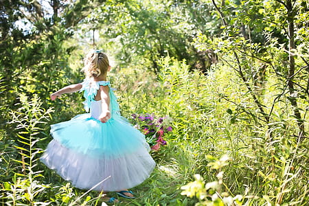 girl wearing blue and white tutu dress standing on grass