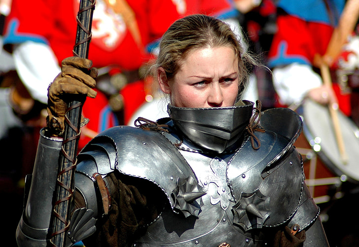 woman wearing silver-colored knight armor while holding spear