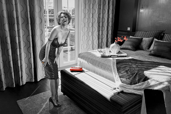 grayscale photo of woman standing near mattress