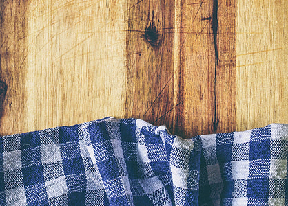 blue and white gingham textile on brown wooden surface