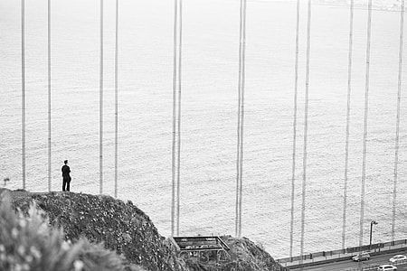 Man Stands at The Edge of The Cliff Near The Golden Gate Bridge