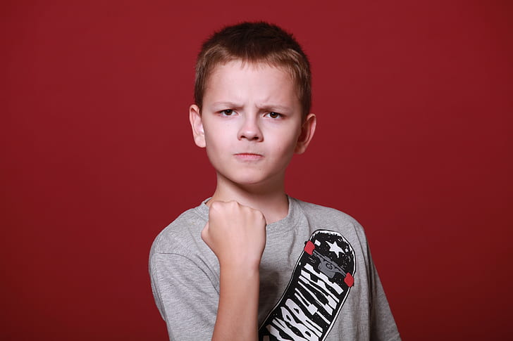 boy in red shirt showing fist