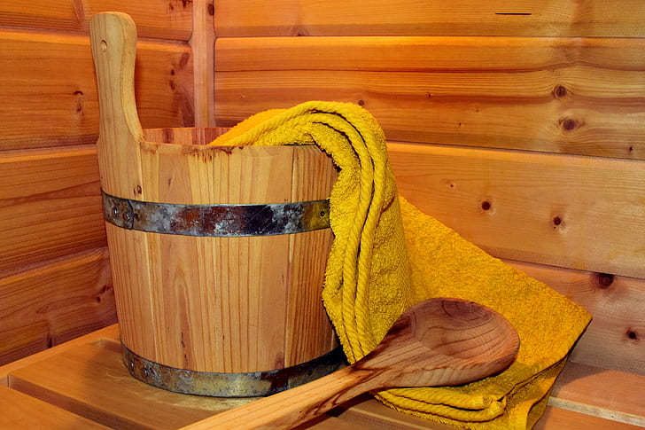 brown wooden ladle beside bucket