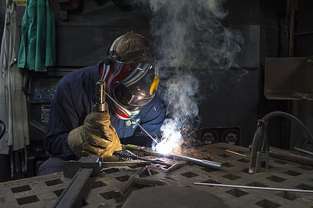 man wearing mask welding gray tool