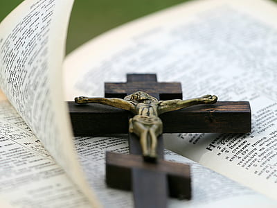brown wooden crucifix on bible page