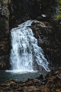 photo of waterfalls near rock mountain