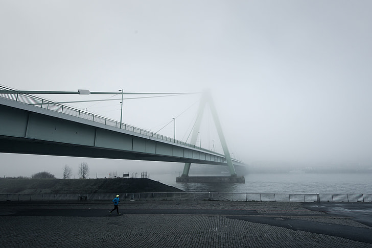 concrete bridge covered with fogs at daytime