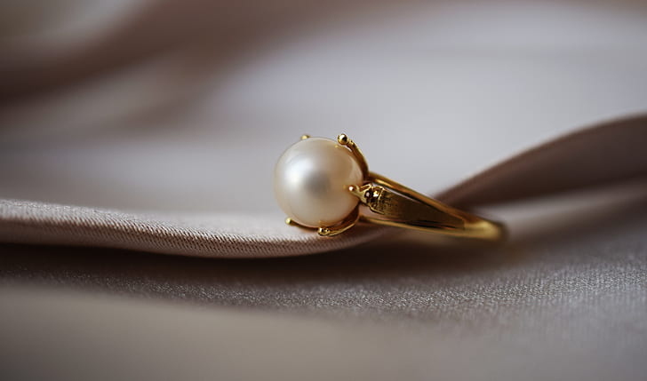 gold-colored ring with white pearl