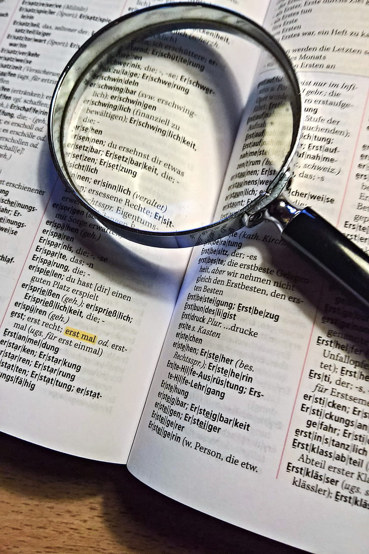 black magnifying glass on dictionary