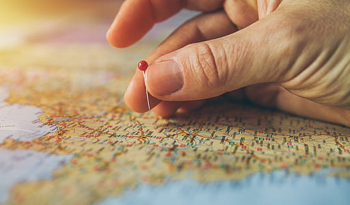 person holding pin on map