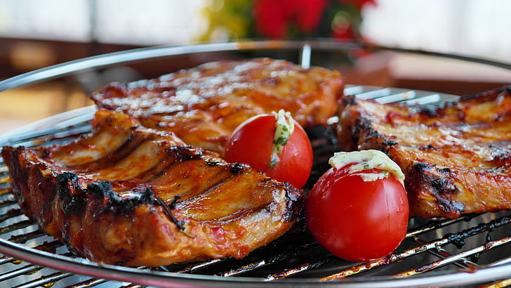 baby back ribs grilled on grilling tray with red tomatoes