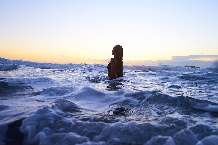 woman in ocean during daytime photography