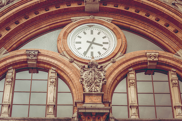 low-angle photo of dome brown building with analog clock