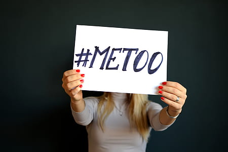 person holding a paper with #METOO text