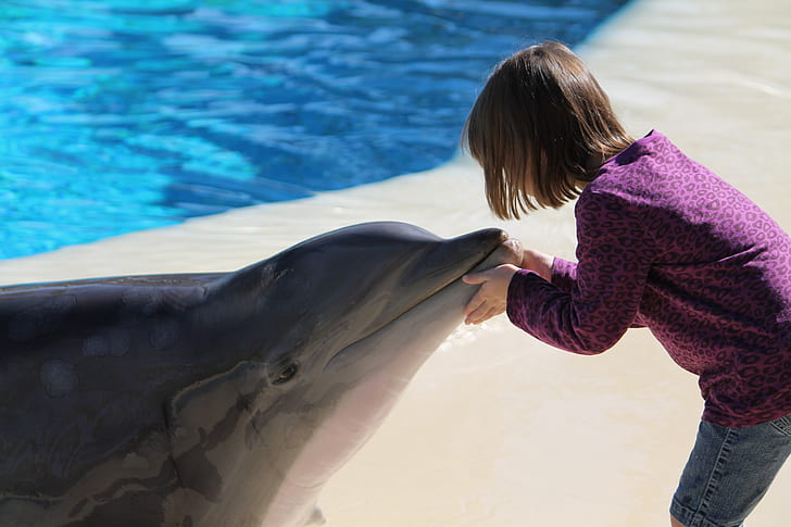 photo of girl holding mouth dolphin