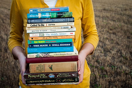 person in yellow shirt carrying books