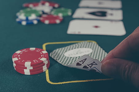 person holding Ace and King of hearts playing cards