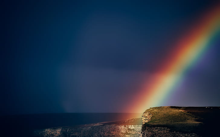 photo of cliff with rainbow