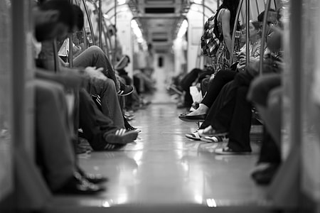 grayscale photography of people sitting in train