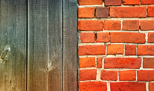 brown bricked wall beside brown wooden panel