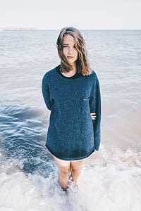 woman in black long-sleeved shirt standing on body of water