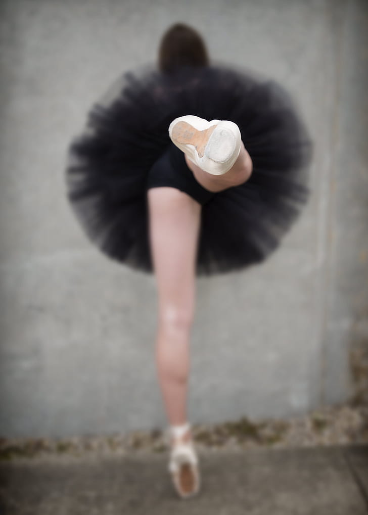 woman wearing black tutu skirt performing ballet dance