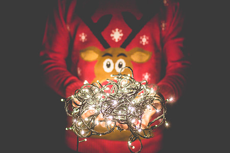 Man in Christmas Sweater Holding Christmas Lights