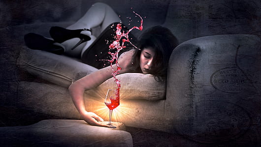 time lapse photo of woman lying on sofa holding wine glass filled with red liquid