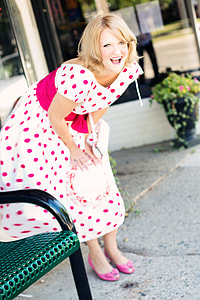 woman in white and pink polka-dot dress standing on pathway
