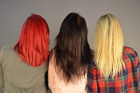 three woman with colored hairs wearing shirts