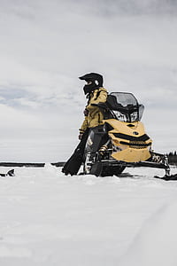 photo of man sitting on snowmobile