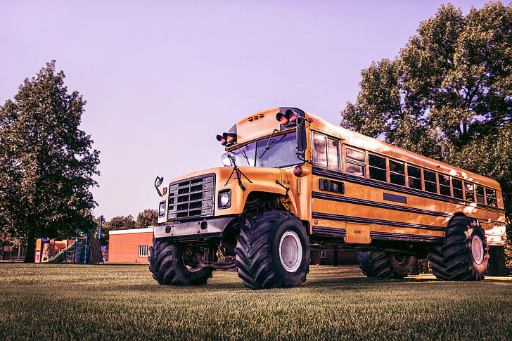 yellow school bus on grass field at daytime