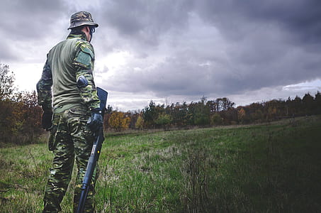 Man in Camouflage Soldier Suit While Holding Black Hunting Rifle