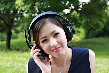 woman in blue sleeveless top and black headphones