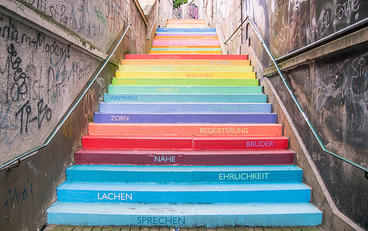 multicolored stairway with text and graffiti at daytime