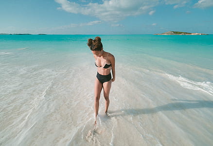 woman in black 2-piece bikini on seashore