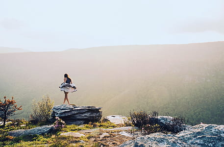 woman standing on cliff during daytime