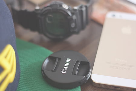 Canon Lens Cover Beside Gold Iphone 5s and Casio G Shock Chronograph Watch