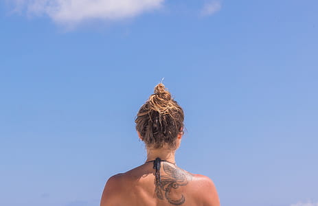 woman with back tattoo during day time