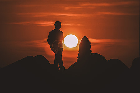 silhouette photo of man and woman on mountain