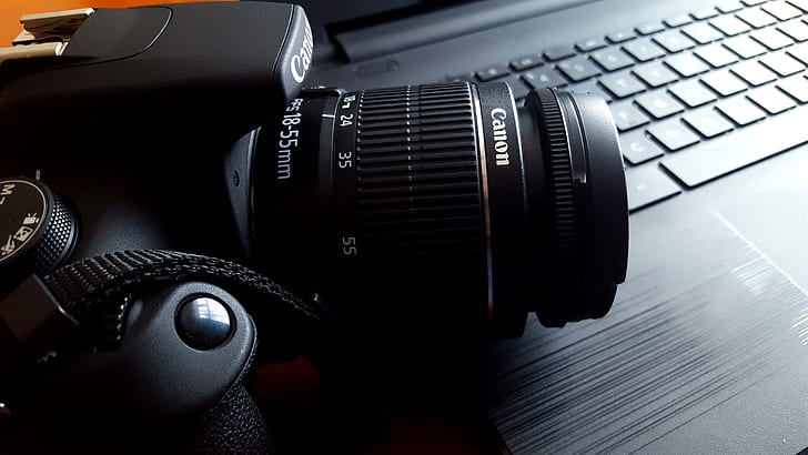 black Canon DSLR camera on black laptop